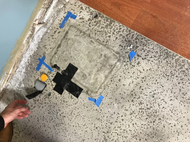 A hole in the cement floor that has been patched